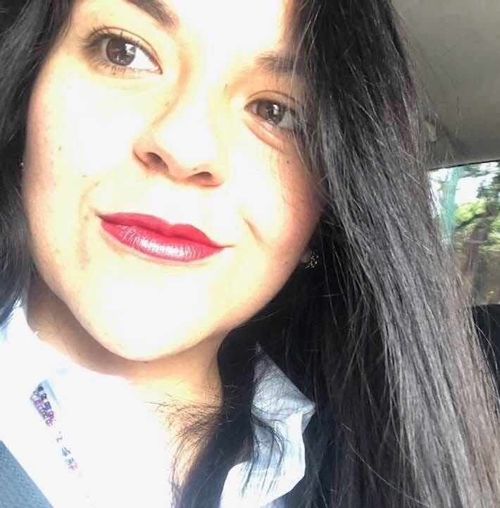 A woman with long black hair and red lipstick.