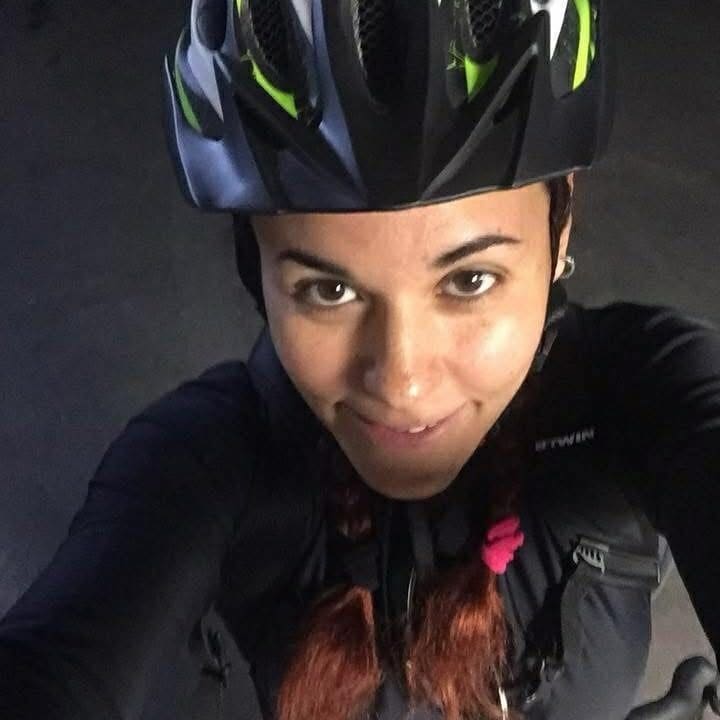 A woman wearing a helmet and riding gear.