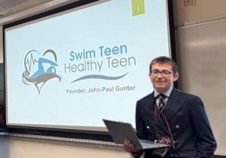 Person presenting in front of a screen.