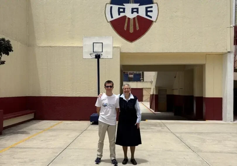 Two people standing in front of building.